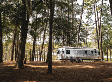 An Airstream Classic parked in the woods during a camping trip.
