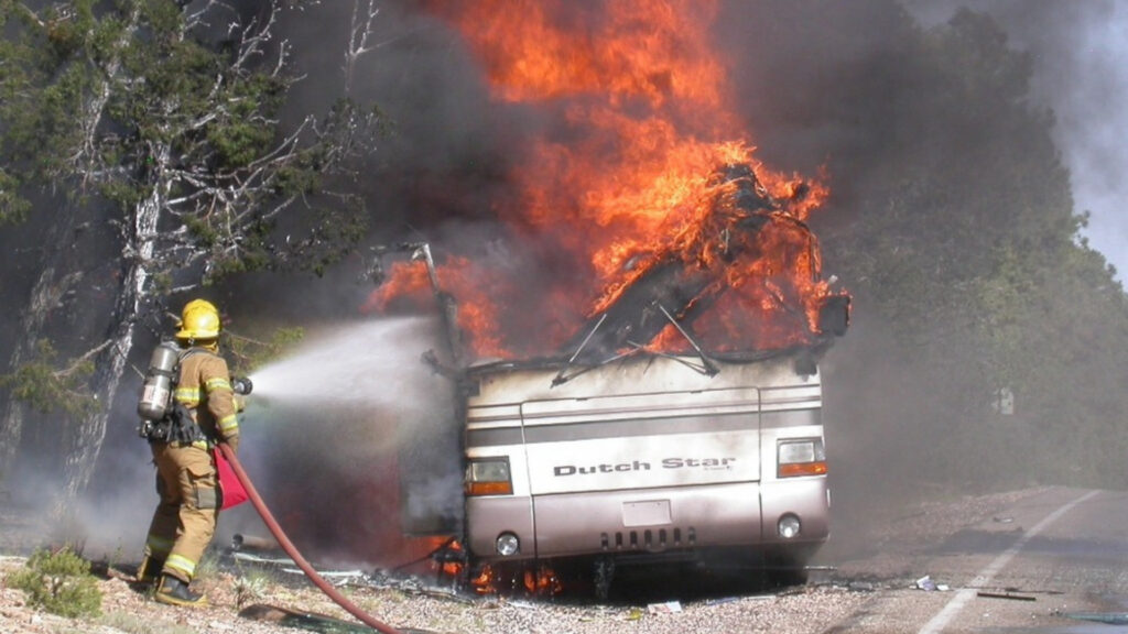 A fire fighter putting out an RV on fire in Grand Canyon National Park.