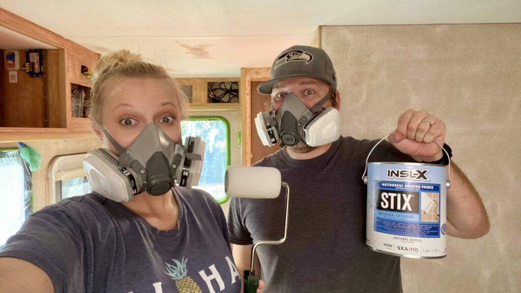 A couple wearing masks while remodeling their truck camper.
