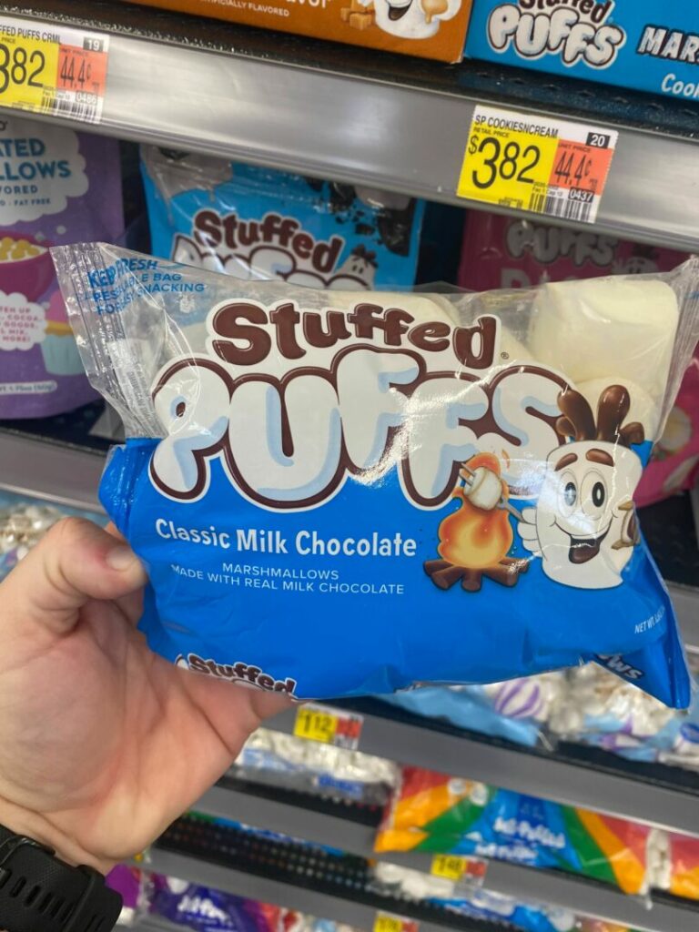 A person holding a bag of stuffed puff s'mores in a grocery store.