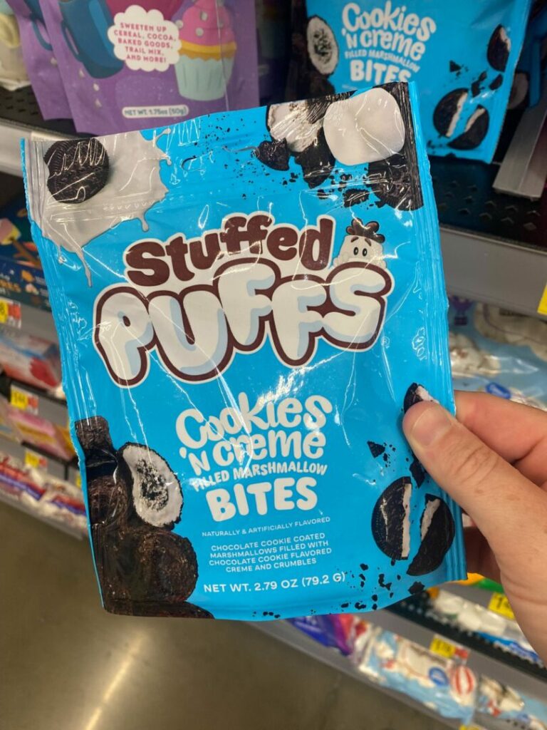 A person holding a bag of stuffed puff bites in a grocery store.