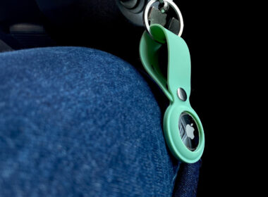 Close up of an AirTag attached to a set of keys in a car.