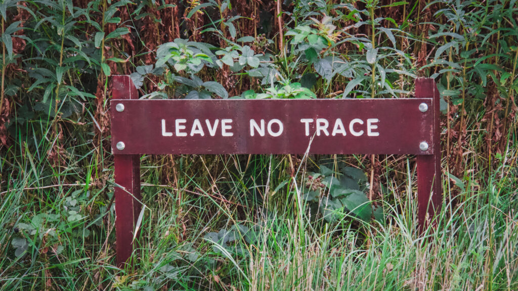 A sign in a national forest reminding visitors to leave no trace behind.