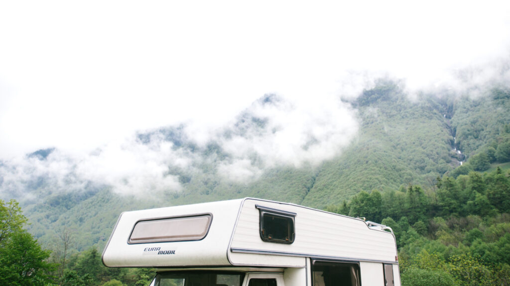 An RV parked on a mountain in foggy conditions.