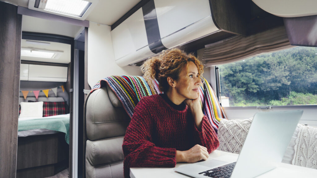 A woman on her laptop in her RV while on rv life pro.