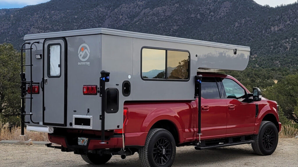 View of an Outfitter Apex 8, a small truck camper in the mountains.