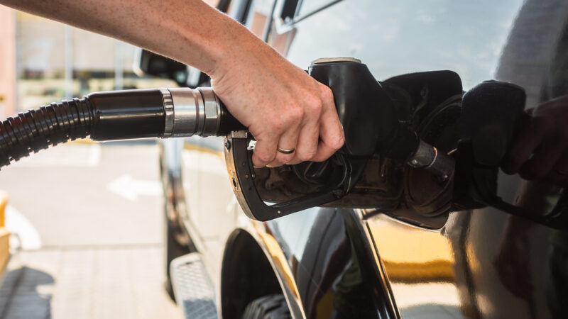Close up of person filling up their Diesel engine with gas at a gas station.