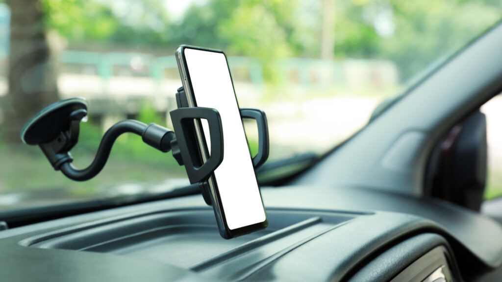 A cellphone attached to a mount inside a vehicle.