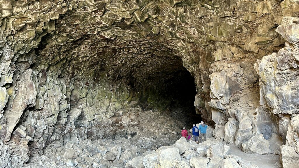 A group of people heading down into Skull Cave at lava beds national monument. 