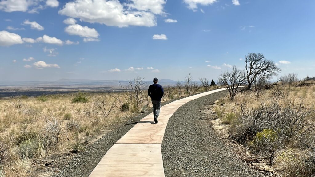 A man walking the path to a lava tube at lava beds national monument. 