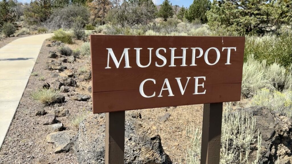 A sign that reads "Mushpot Cave" and a walkway behind it. 