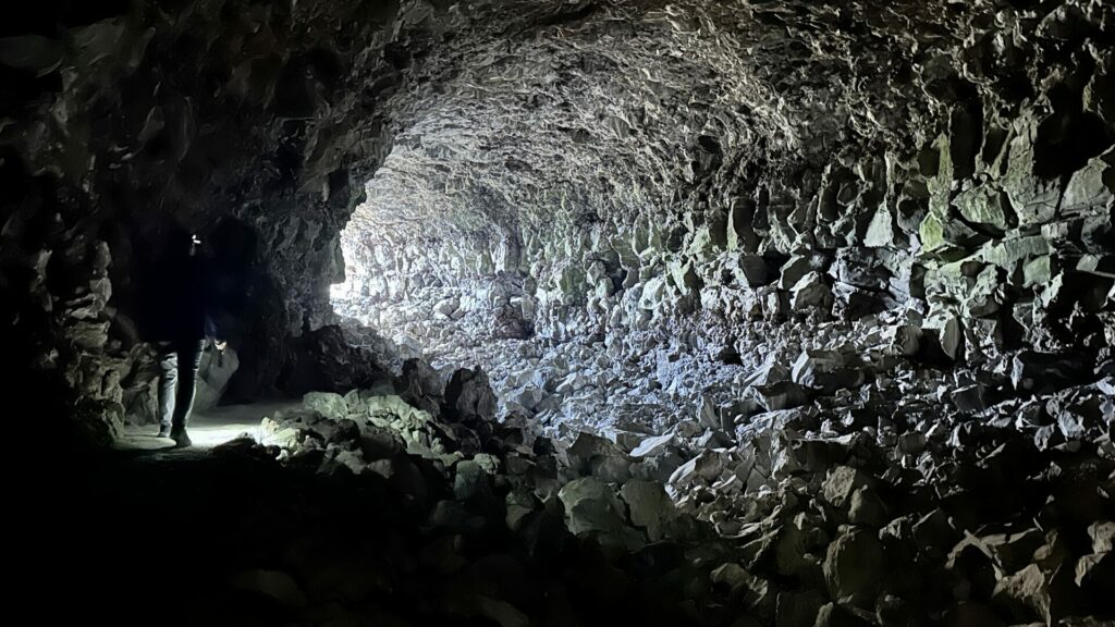 A man exiting Skull Cave at lava beds national monument. 