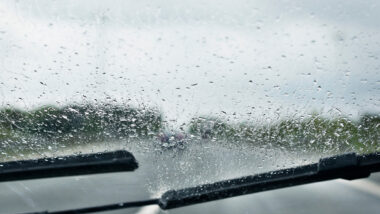 Close up of a windshield of a vehicle driving in the rain.