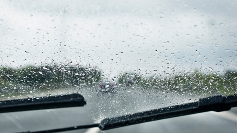 Close up of a windshield of a vehicle driving in the rain.