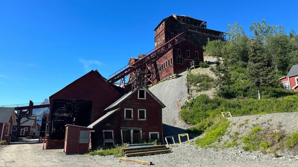 view down the road showing red wooden abandoned buildings of the kennicott copper mine
