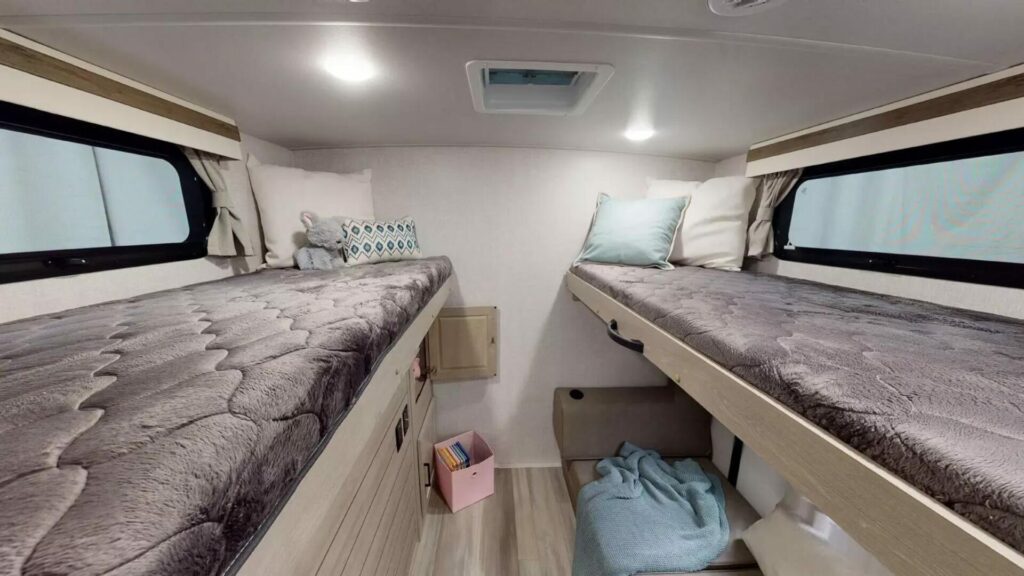 Interior shot of a travel trailer with two beds for kids in the back.