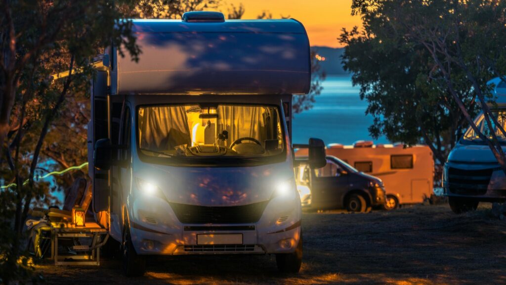 A camper van at a campground at night.