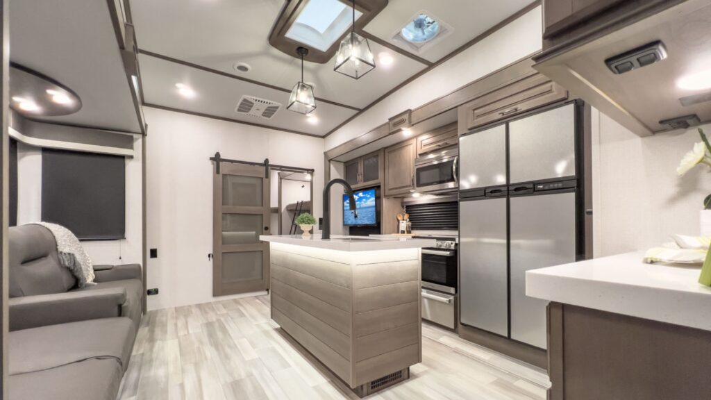 Interior picture of the Grand Design Solitude 3740BH showing the kitchen and living space. This is one of the best fifth wheel for a family of 5 because of the unique layout.
