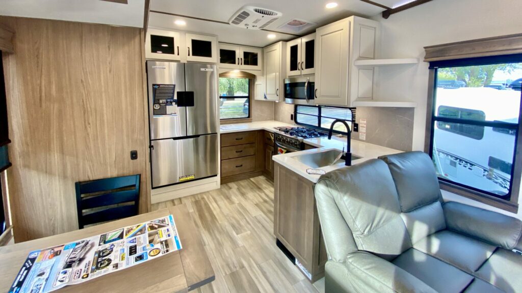Interior shot of an RV where the floorplan has the kitchen in the rear of the fifth wheel. 