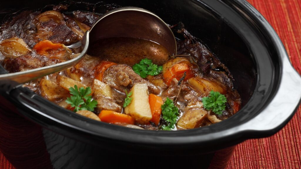 a slow cooker with a beef stew inside.