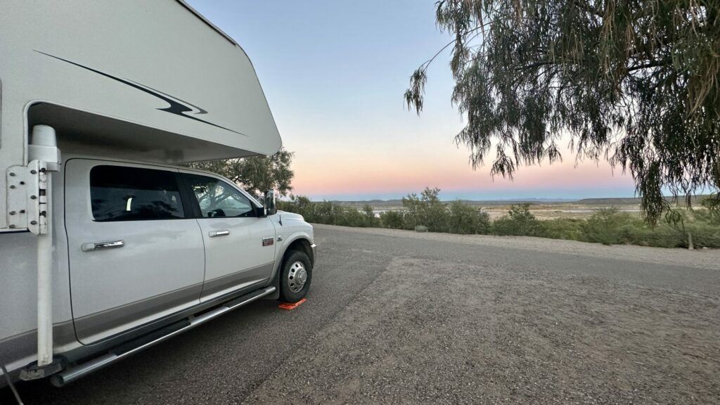 Our truck camper parked in a campsite overlooking the sunset.