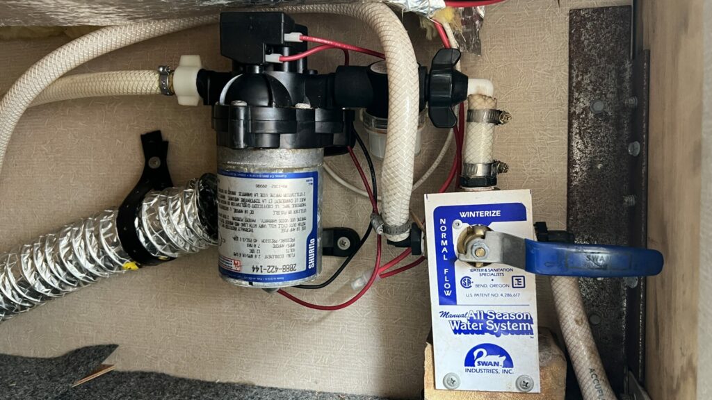 RV water pump on wall with winterize vavle