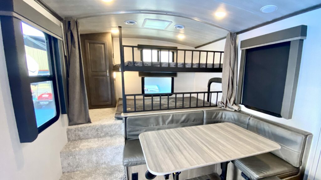 The back of a travel trailer with bunk beds that can be blocked off with a curtain.  It's important to consider where children will sleep when looking at RV floor plans. 