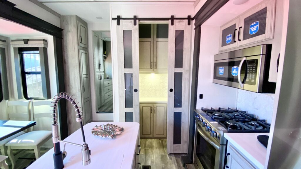 The kitchen area of a fifth wheel with a pantry in the back. It's important to consider the kitchen layout when looking at RV floor plans. 