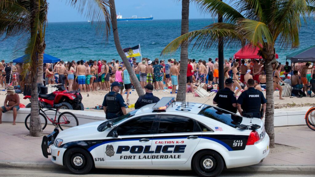Spring breaks on the beach in Fort Lauderdale being watched by the police
