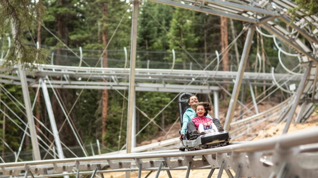 A mother and daughter ride down the blue ridge mountain coaster at an RV park