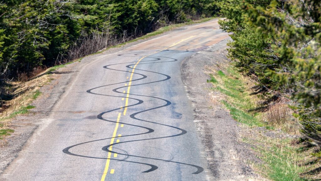 A road with swerving skid marks left on it. 