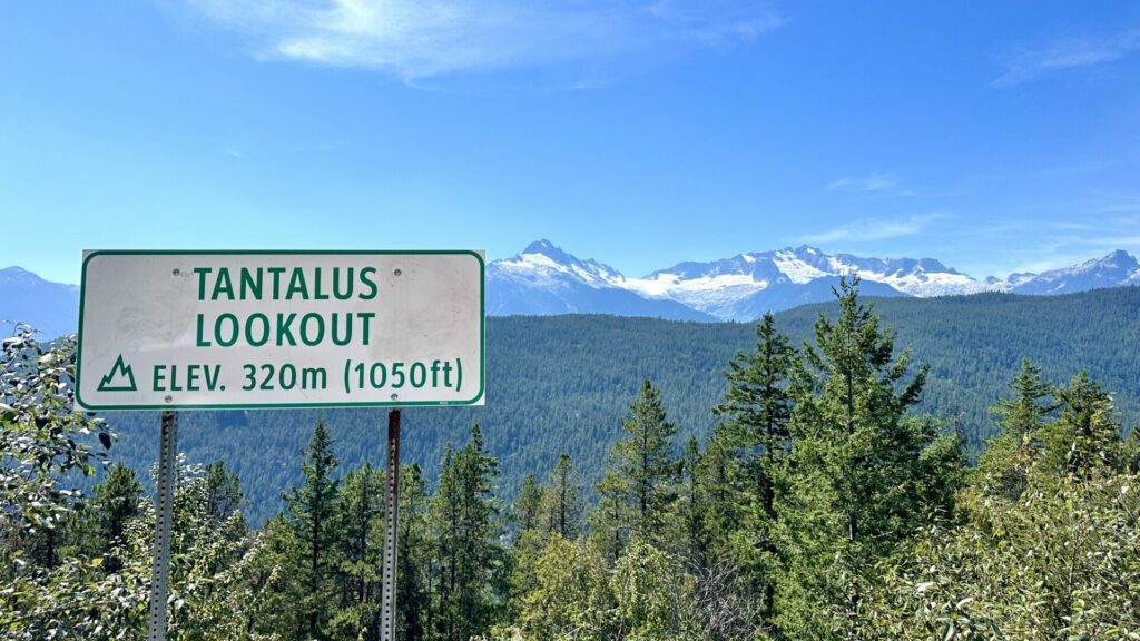 The Tantalus Lookout sign with the mountains in the background. 