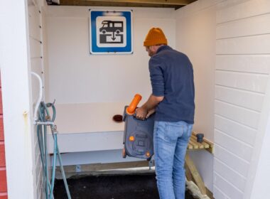 man dumping Cassette Toilet into a dump station in europe