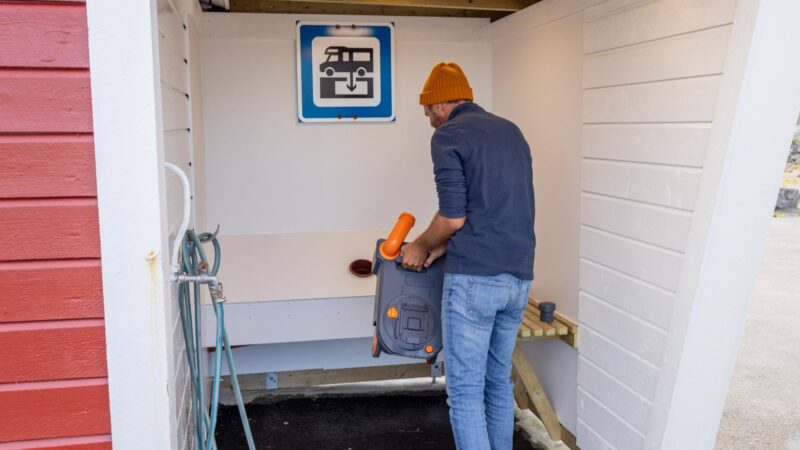 man dumping Cassette Toilet into a dump station in europe