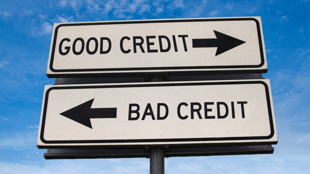 A sign that says good credit and points right and a sign that says bad credit and points left.