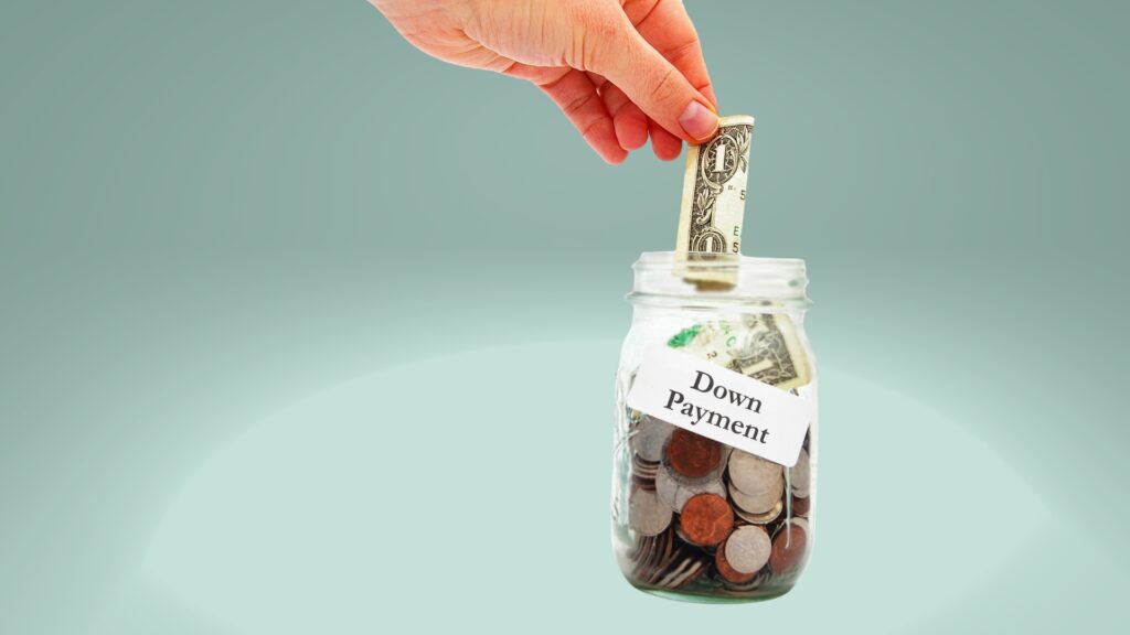A person putting a dollar bill in a jar full of money that says "down payment". Save up a bigger down payment when you want to get RV financing with bad credit.