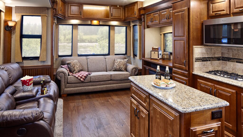 The living room of a Majestic fifth wheel with light brown cabinets and comfortable looking couches.