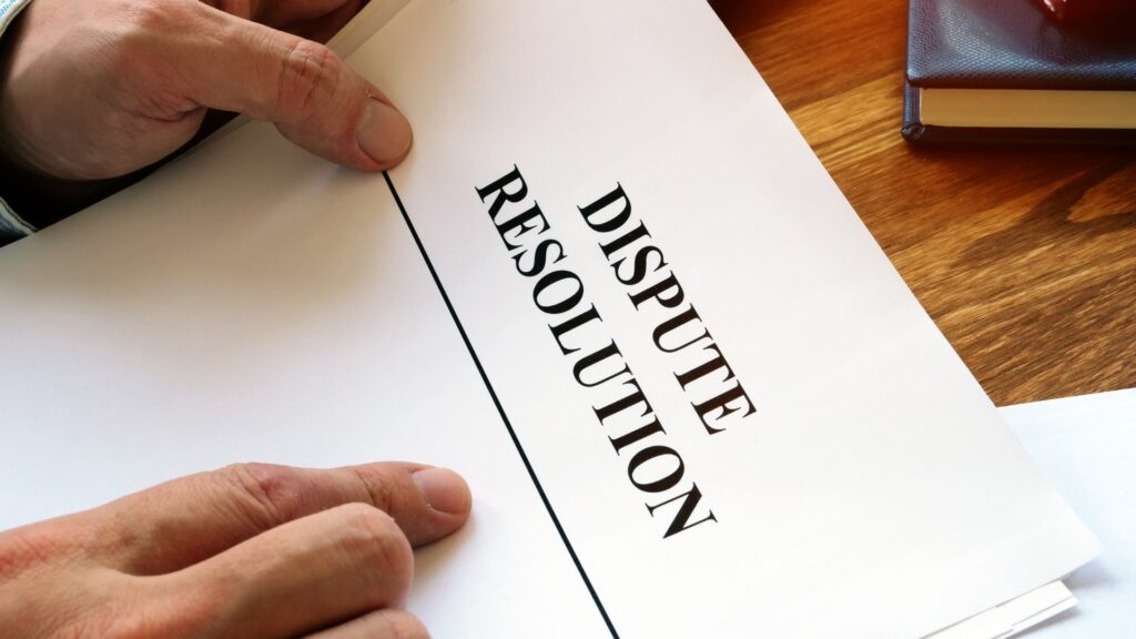 A man holding a piece of paper that says dispute resolution. 