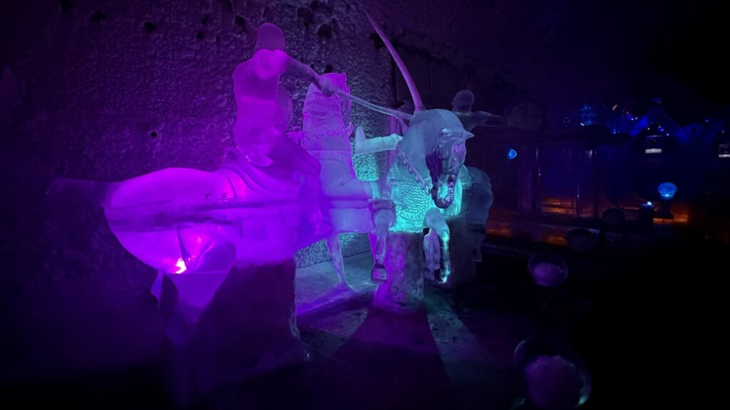 An ice sculpture of a knight on a horse in a dual. 