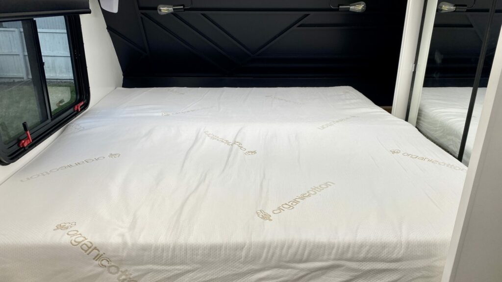 Our Mattress Insider custom bed freshly unrolled in our truck camper.