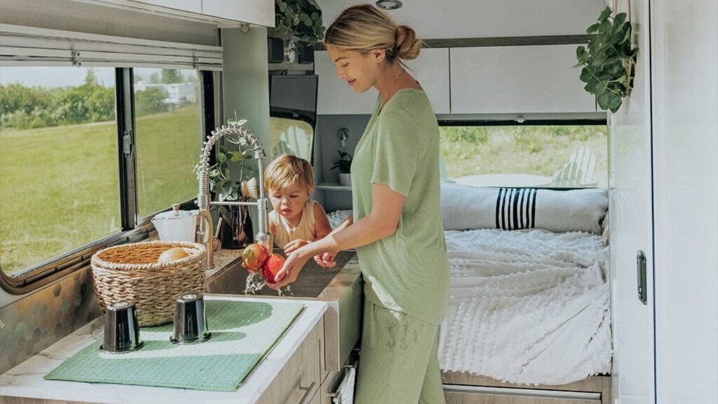 A woman and her child washing apples in the sink of an inTech Sol Horizon. 