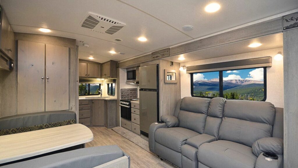 The inside of a northwood manufacturing travel trailer with a rear kitchen, dinette, and loungers.