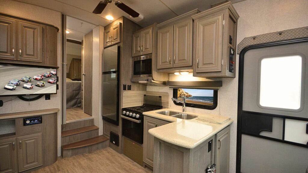 The inside of a Northwood fifth wheel with a center kitchen, TV, and bedroom in the front.