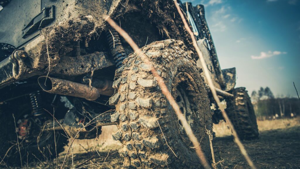 A ground view of a truck with muddy wheels. 