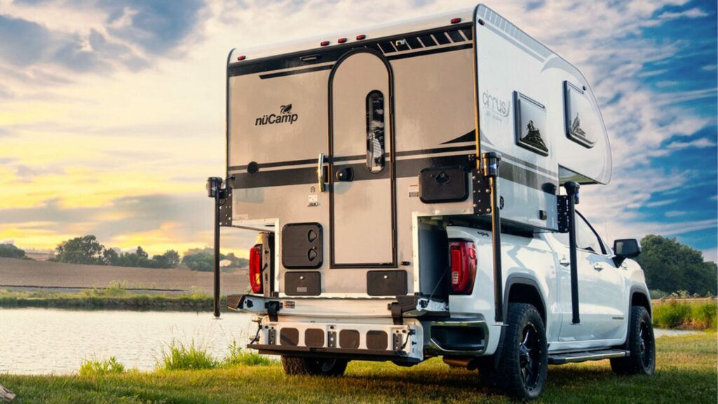 Cirrus Truck Camper by nuCamp in front of a lake.