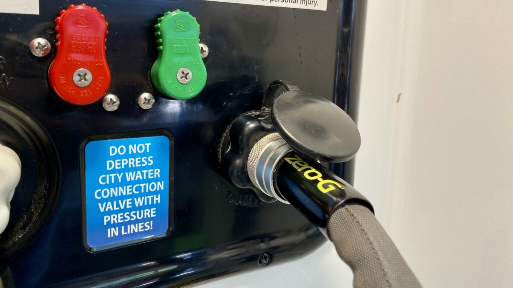 Up close picture of the Zero-G RV fresh water hose connected to our fifth wheel wet bay. 