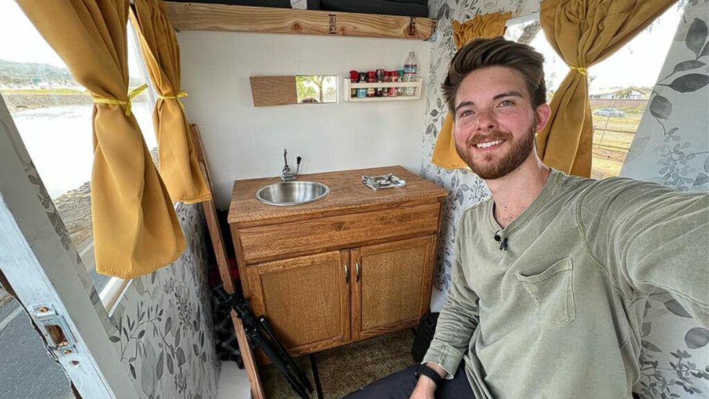 One of the Dangie Bros inside the BikeCamper with a small vanity behind him.