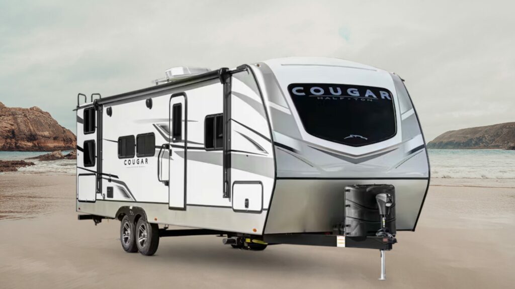 A photo of the Cougar 25MLE RV travel trailer by Keystone with a beach background. 