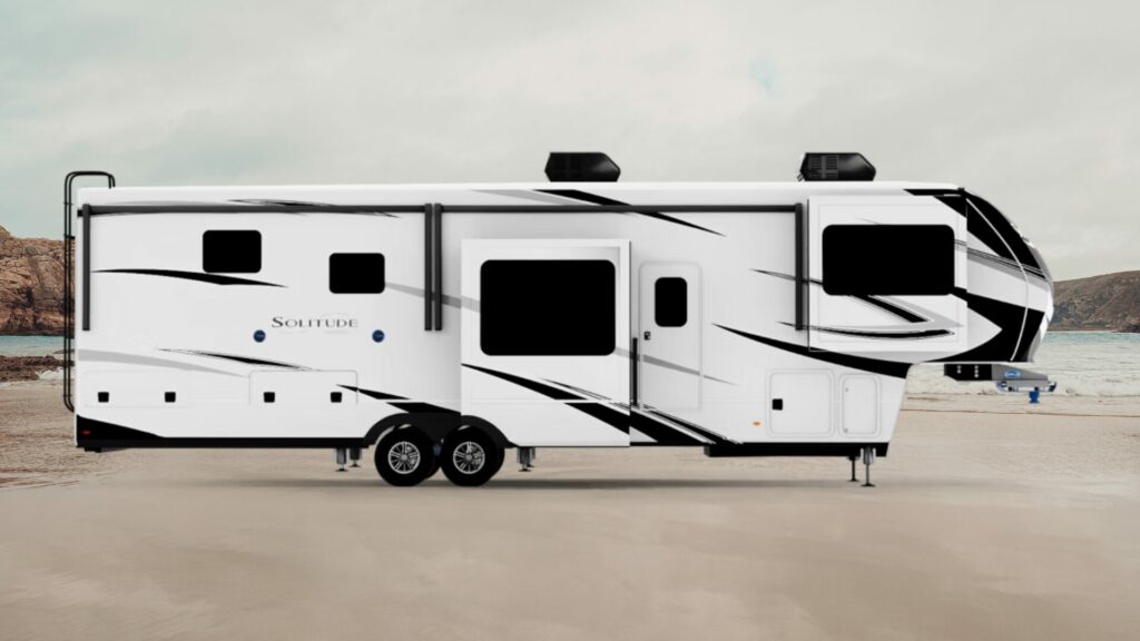 A photo of the Solitude 5th wheel RV with its slideouts out on a beach. 