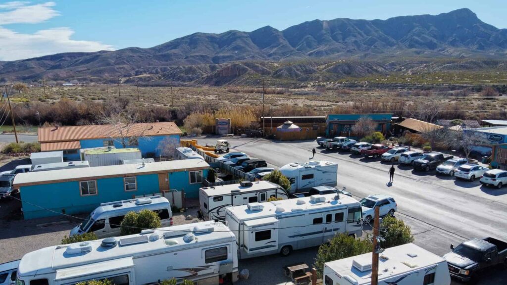 An aerial of the RV Camp at the Riverbend Hot Springs in New Mexico, looking out at the mountains. 